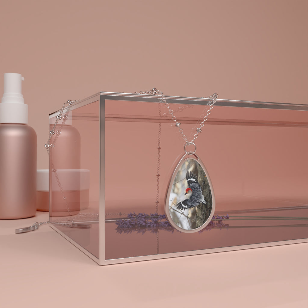 Teardrop-shaped pendant with a red- breasted woodpecker photo