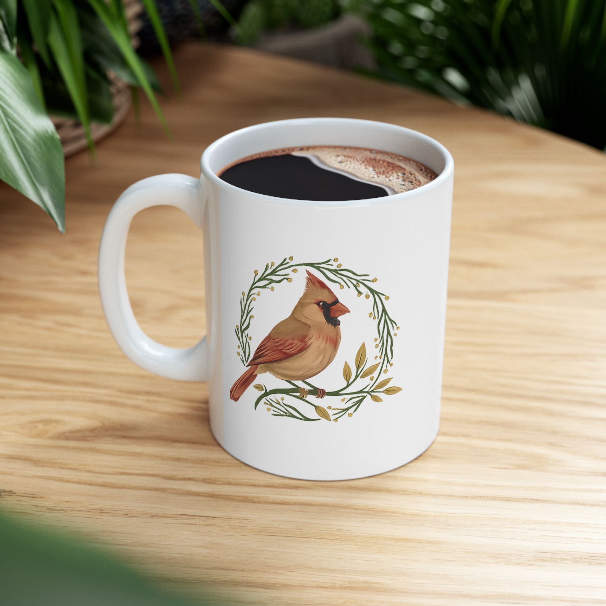 White mug with a cardinal design on a wooden table