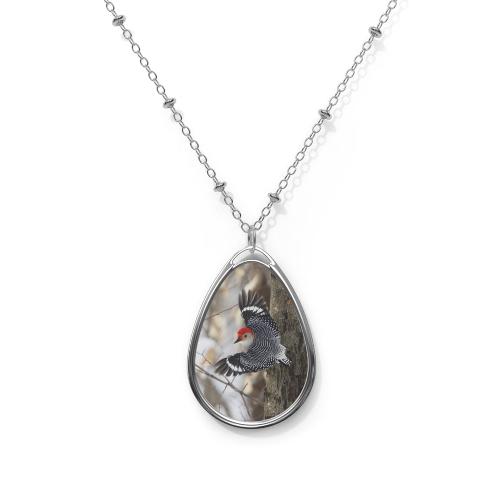 Teardrop-shaped pendant with a red- breasted woodpecker photo