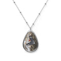 Teardrop-shaped pendant with a red- breasted woodpecker photo