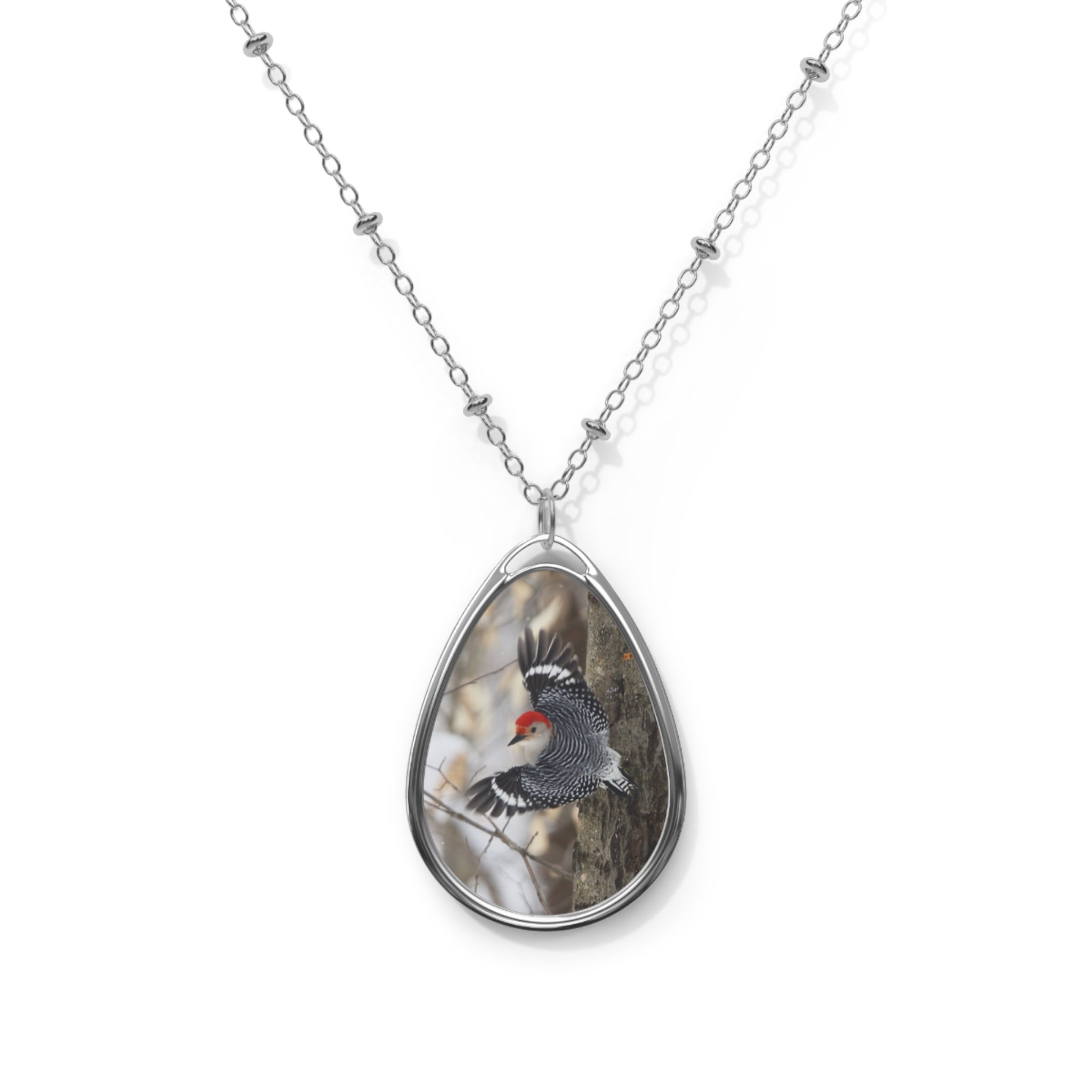 Teardrop-shaped pendant with a red- breasted woodpecker photo