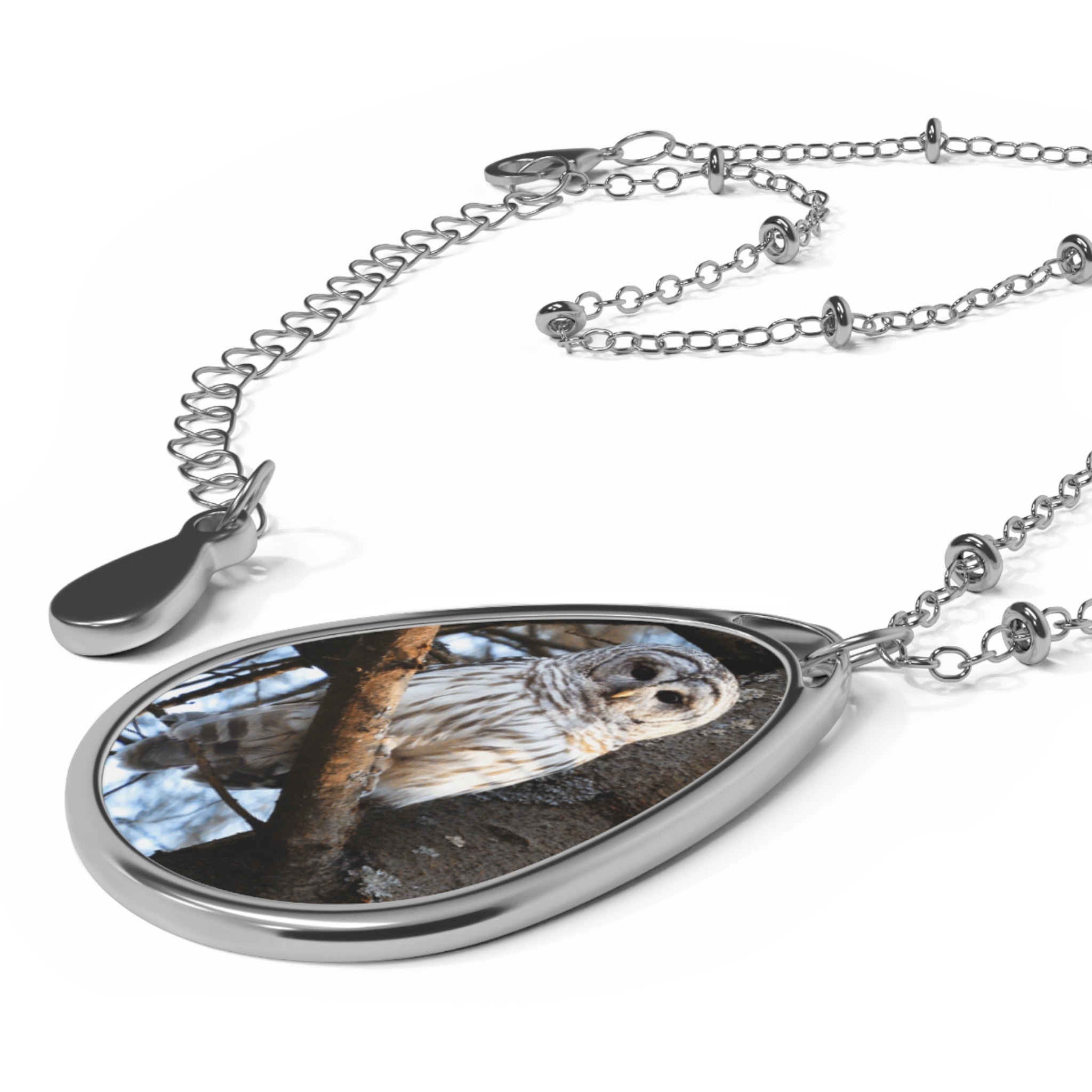 Teardrop-shaped pendant with a cedar barred owl photo