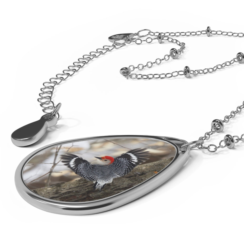 Teardrop-shaped pendant with a red- breasted woodpecker photo